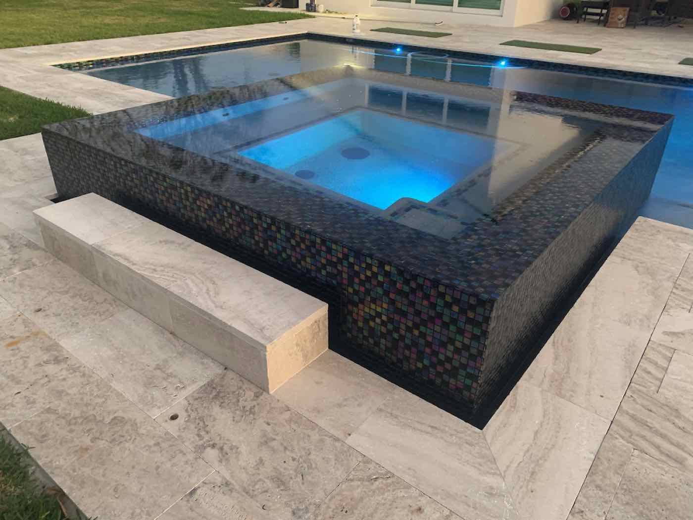 Attached spa and sun shelf engineered into a new pool build