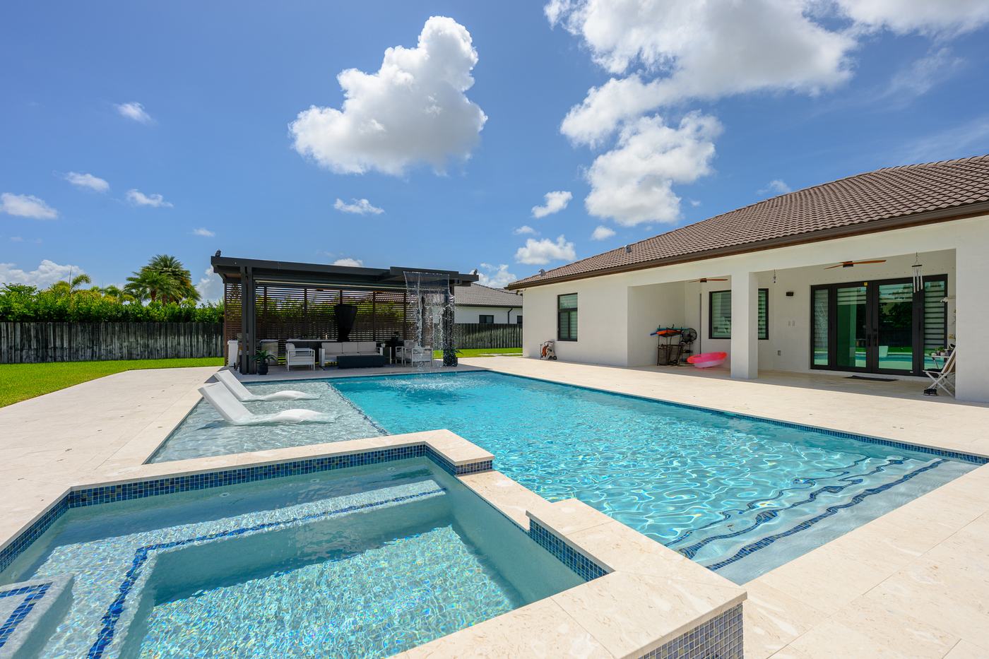 Poolside pergola cabana beside a custom pool and spa built by Dream Pools FL in Miami-Dade County