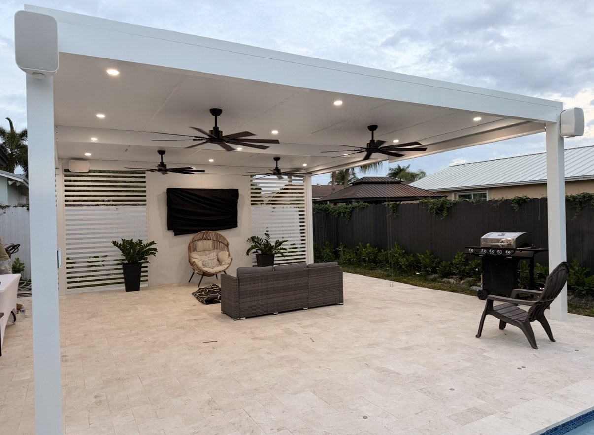 Covered patio pergola with ceiling fans and lounge seating beside a custom pool in Miami-Dade County