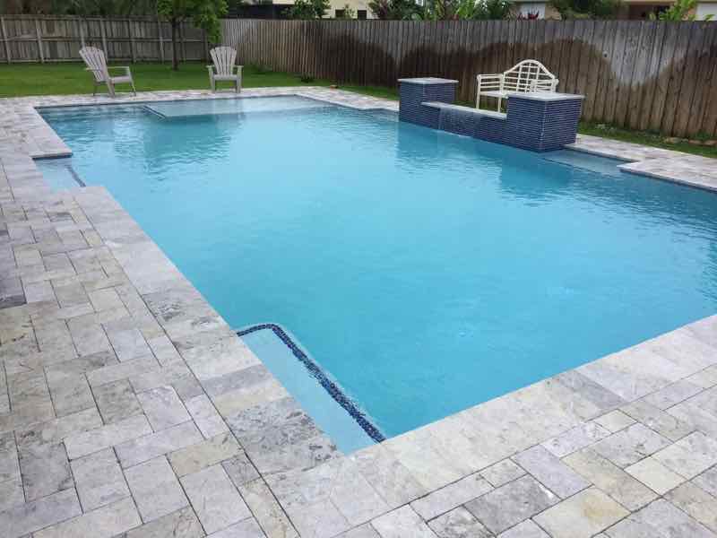Rectangular pool with a raised stone fountain accent on a bluestone deck