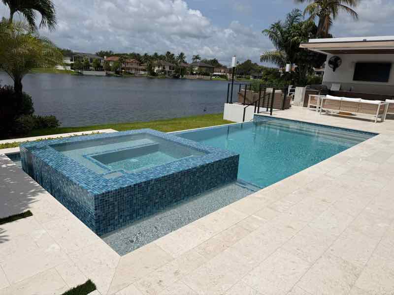 Custom lakefront inground pool with outdoor living space built by Dream Pools FL in Miami-Dade County