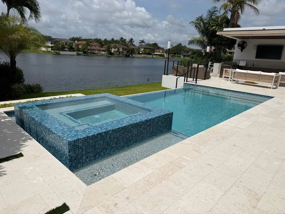 Custom lakefront inground pool with outdoor living space built by Dream Pools FL in Miami-Dade County