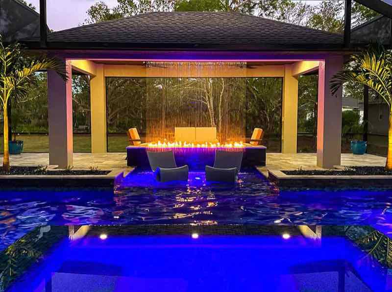 Illuminated rain curtain and fire feature on a custom pool built by Dream Pools FL in Miami-Dade County