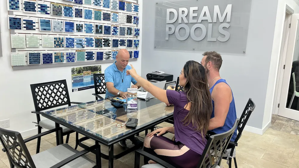 Construction workers reviewing blueprints and permits for a Florida swimming pool project
